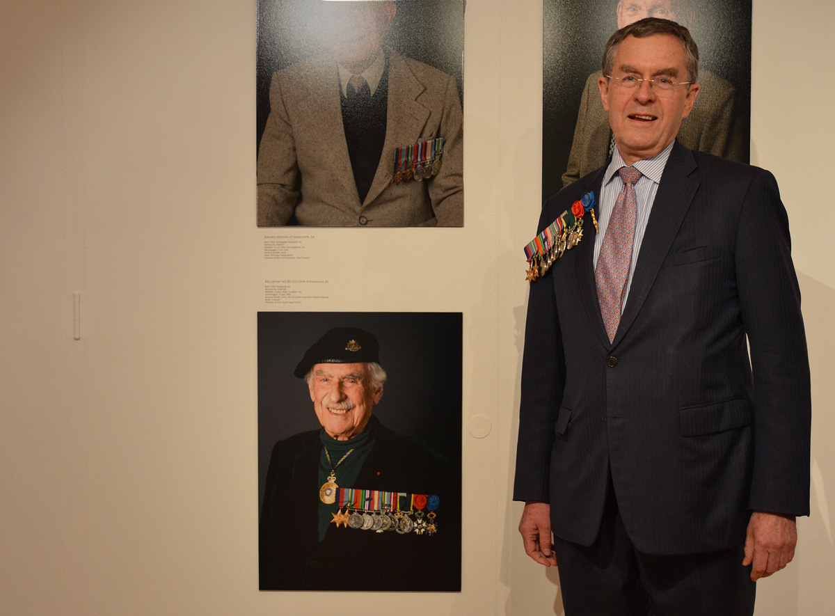 Gerald Lipman standing in front of his father Rex Lipman's portrait taken 11 days before he passed away in 2015.