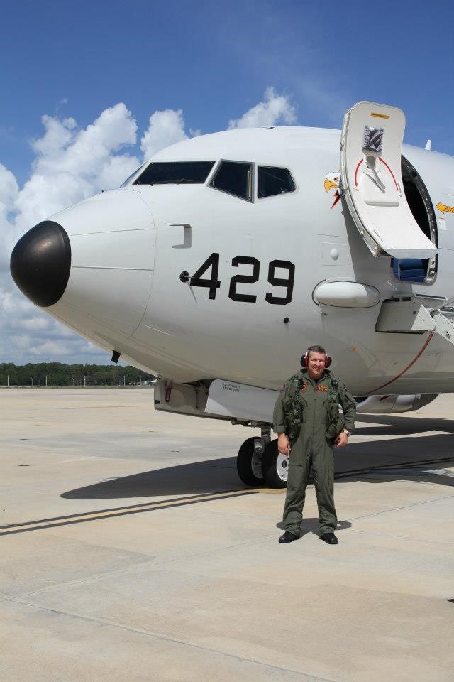 Glen Gallagher on the tarmac next to a military aircraft.