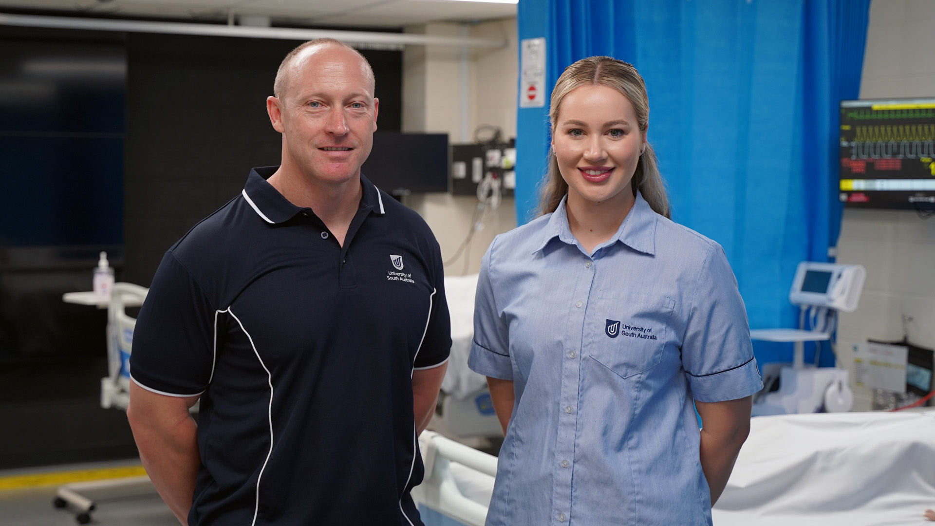 Two people standing in a hospital setting