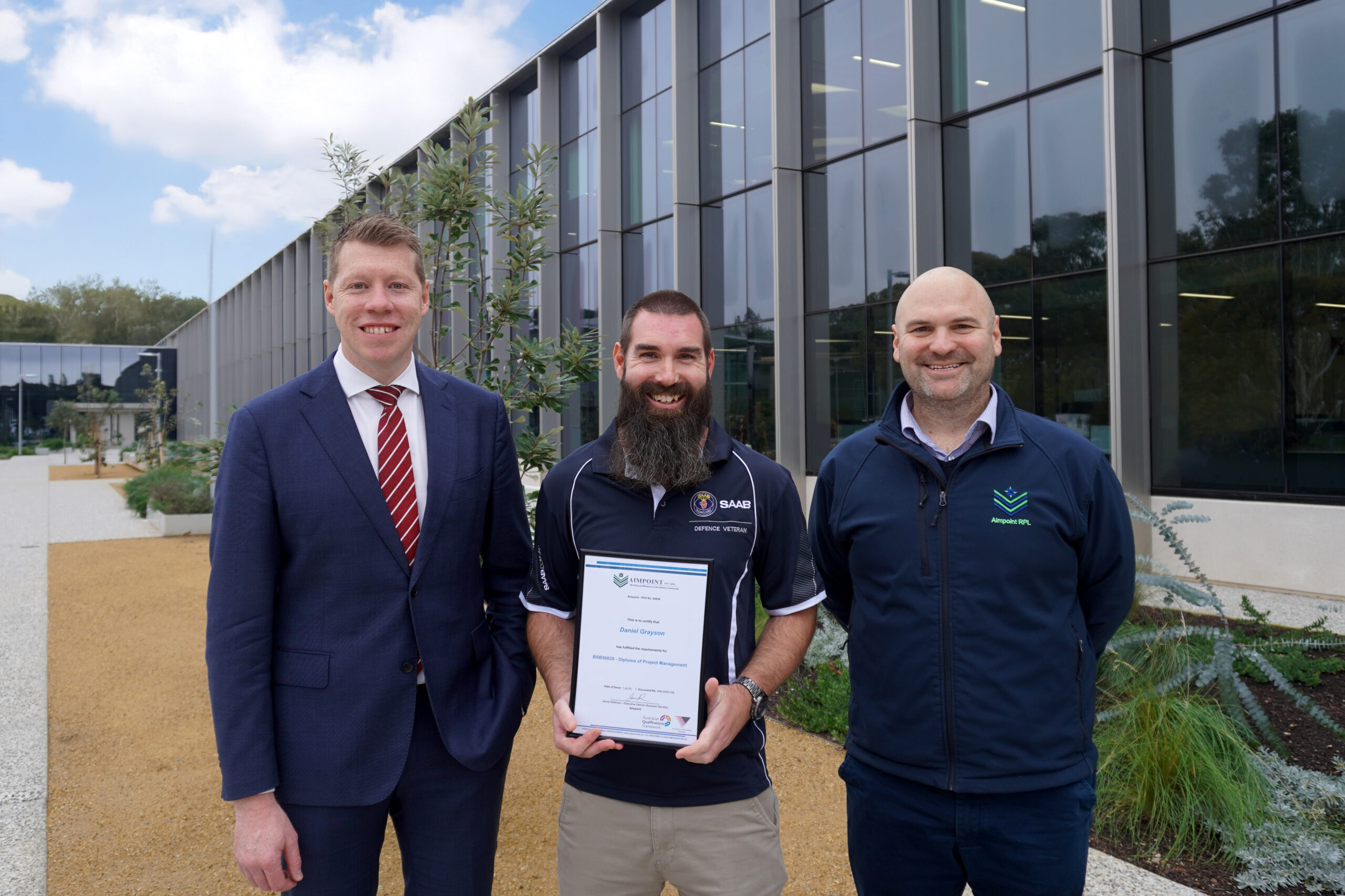Pictured on his graduation day at Saab’s Mawson Lakes site is Saab Australia Maintenance Manager Daniel Grayson being congratulated by (left) Minister for Veterans Affairs, the Hon. Joe Szakacs MP and Aimpoint CEO Mark Robinson.
