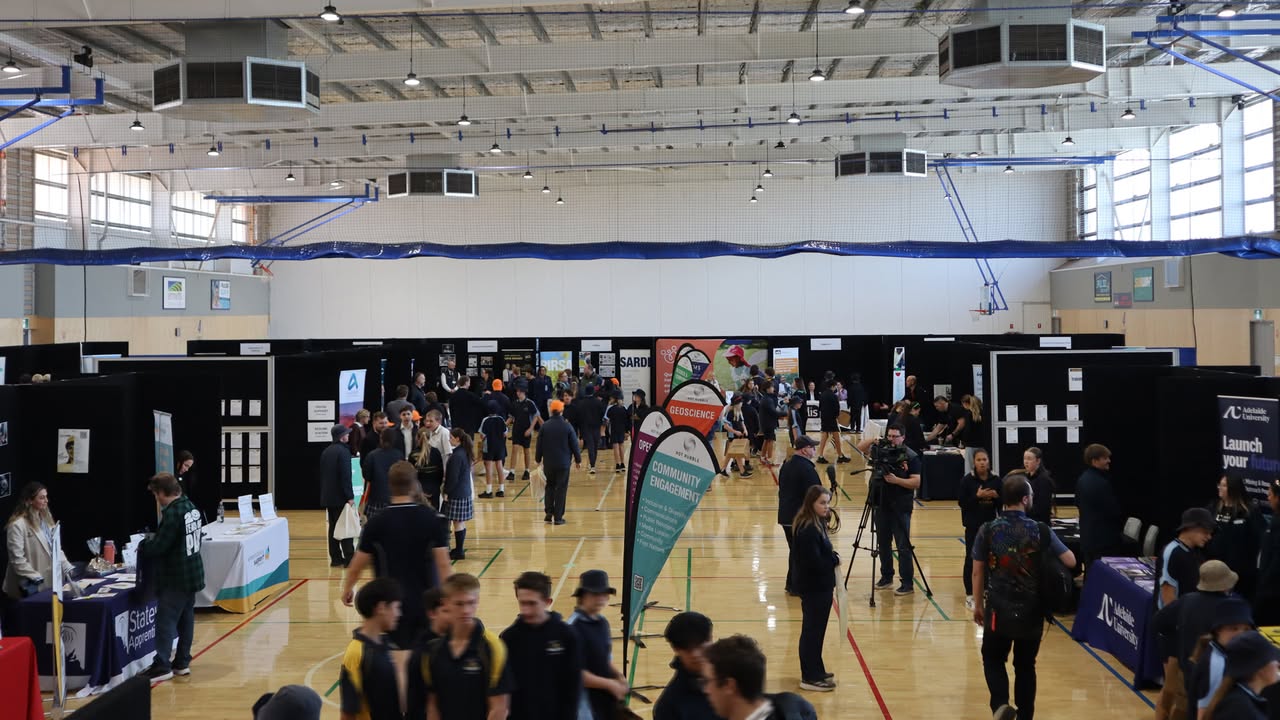 Students and attendees exploring booths at an exhibition