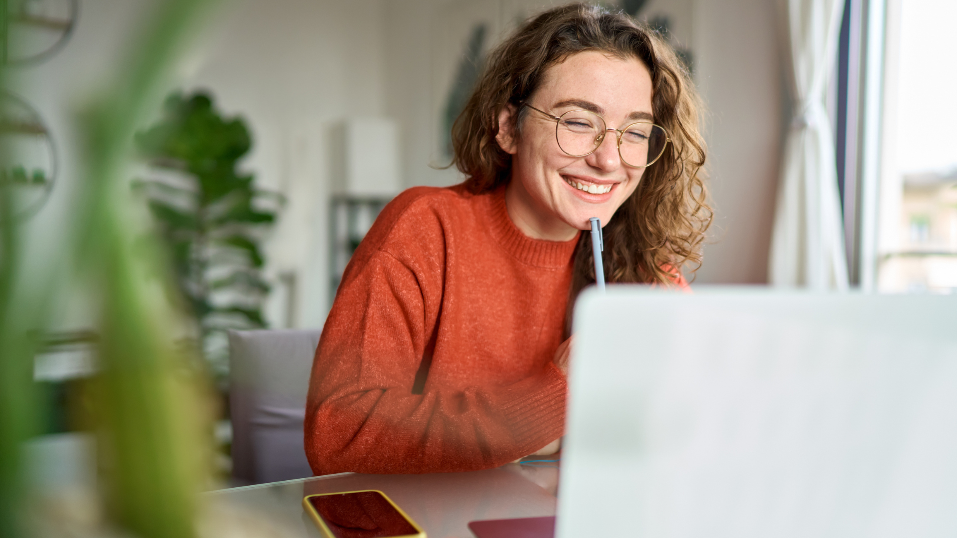 Girl sitting in front of a laptop in a home environment