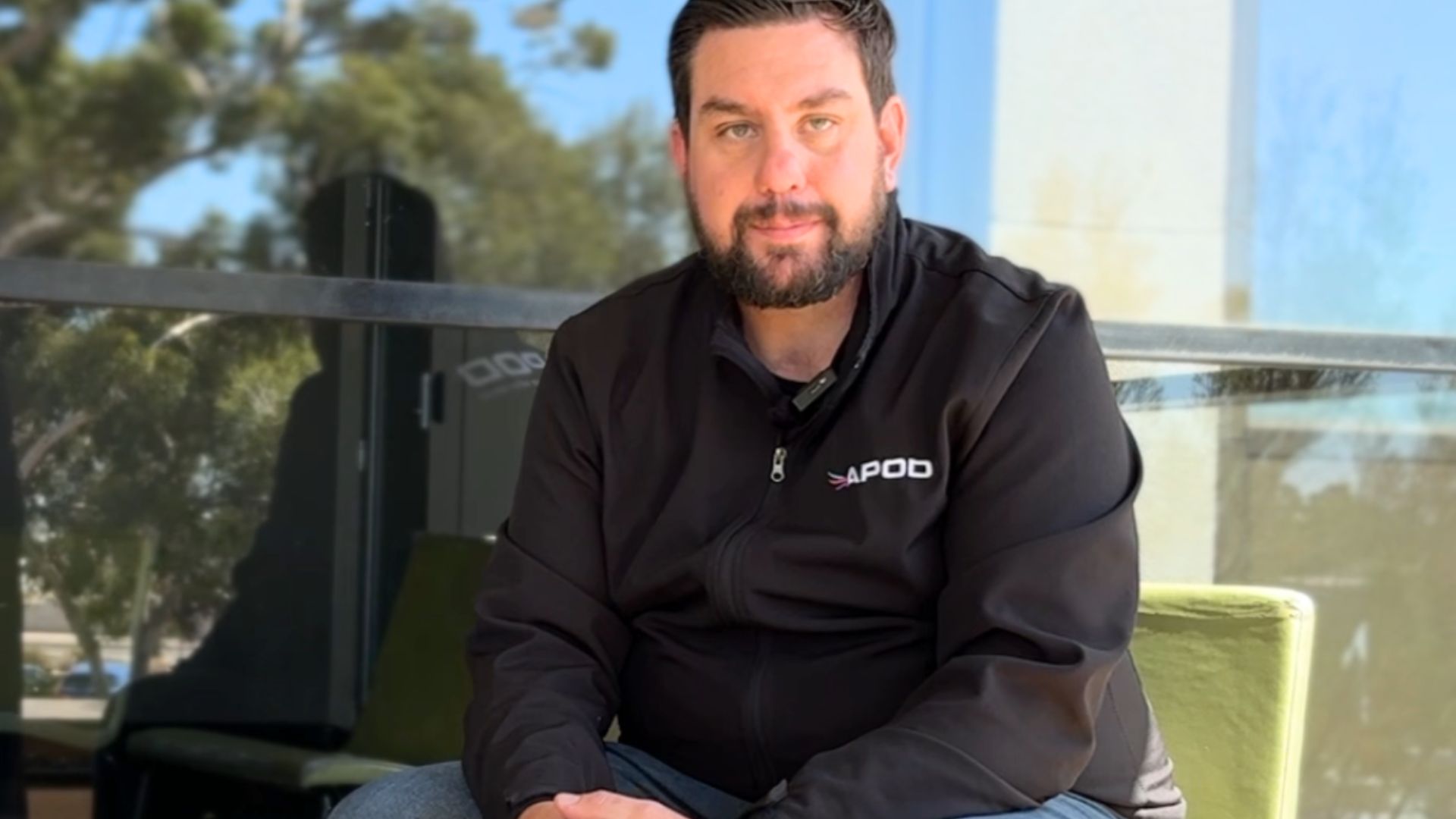A man sitting looking at the camera in a casual setting.