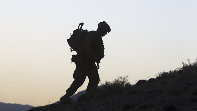 Silhouette of a soldier walking up a hill